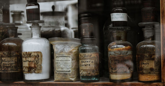 Assorted single homeopathic remedies in small glass bottles on a wooden shelf, representing a buying guide for UK shoppers.