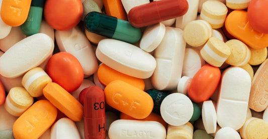 A bottle of multivitamin for men over 40 UK standing on a wooden surface with a few tablets scattered around, symbolising daily health support.