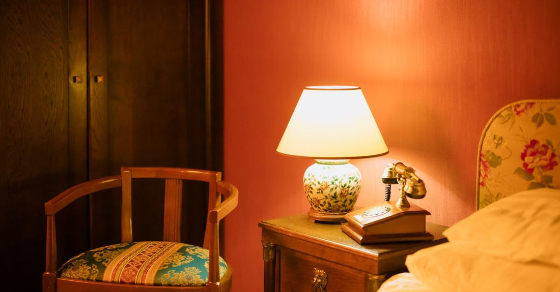 A pair of soft silicone earplugs resting on a wooden bedside table next to a glass of water, illustrating a practical earplugs buying guide UK for better sleep.