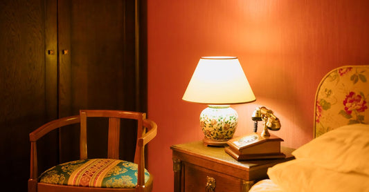 A pair of soft silicone earplugs resting on a wooden bedside table next to a glass of water, illustrating a practical earplugs buying guide UK for better sleep.