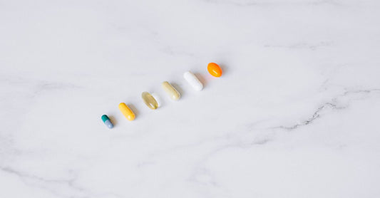 Variety of vitamin and mineral supplement bottles arranged on a light background, illustrating a combinations buying guide UK.