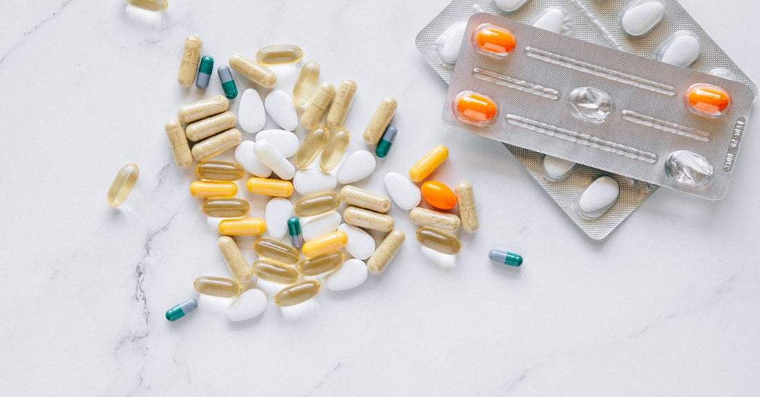 A flatlay of various supplement bottles, capsules, and a checklist, representing how to choose supplements UK.