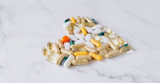 A multivitamin bottle and scattered capsules on a clean white surface, representing the multivitamins buying guide UK