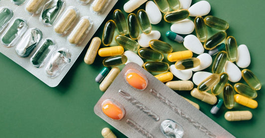 A bottle of multivitamin for seniors surrounded by green leaves on a white surface, highlighting natural supplement choices for over-65s.