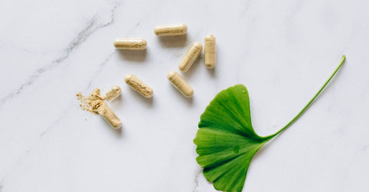 Psyllium husk powder and capsules side-by-side on a wooden surface, illustrating the psyllium husk powder vs capsules choice