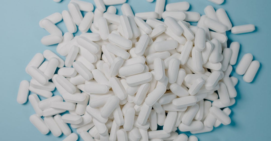 A bottle of nitric oxide supplement for ED on a white background with capsules spilling out
