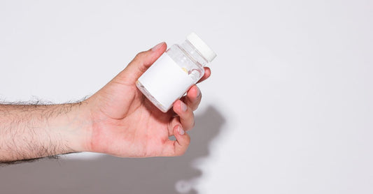 Bottle of magnesium citrate capsules for constipation relief on a white background