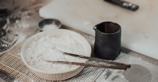 Ashwagandha buying guide: a wooden bowl filled with organic ashwagandha root powder and a spoon on a light surface.