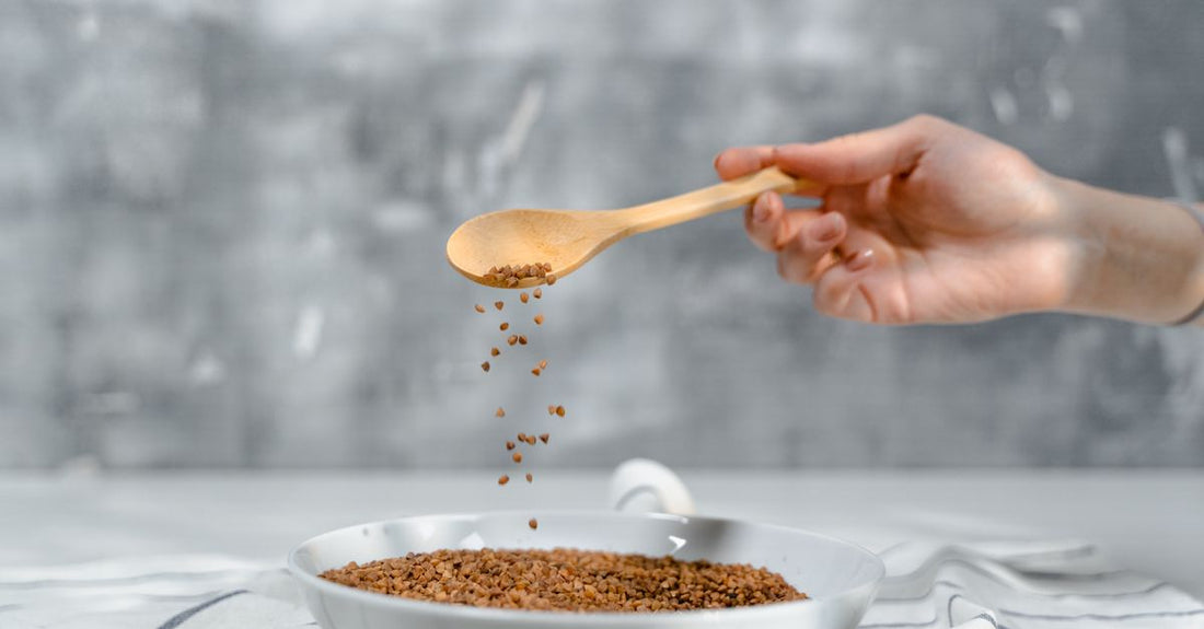 A wooden bowl filled with golden and brown flaxseeds on a light background, illustrating a flaxseed buying guide UK.