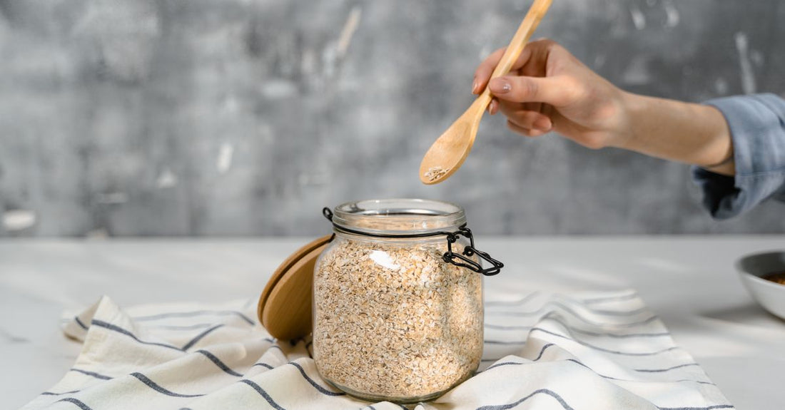 Jar of organic ashwagandha root powder with a wooden scoop on a neutral background, illustrating how to choose ashwagandha supplements.