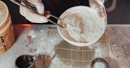 A wooden bowl filled with organic ashwagandha root powder beside a glass of water, illustrating our ashwagandha buying guide for UK shoppers.