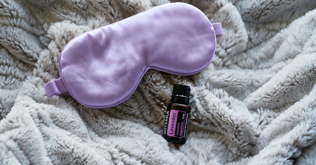 Blackout sleep mask flatlay on a dark surface, showing contoured eye cups and adjustable strap