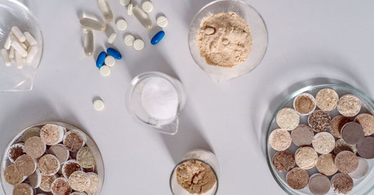 Assorted inositol supplement bottles and a scoop of powder on a clean white surface, illustrating how to choose B8 (inositol) in the UK.