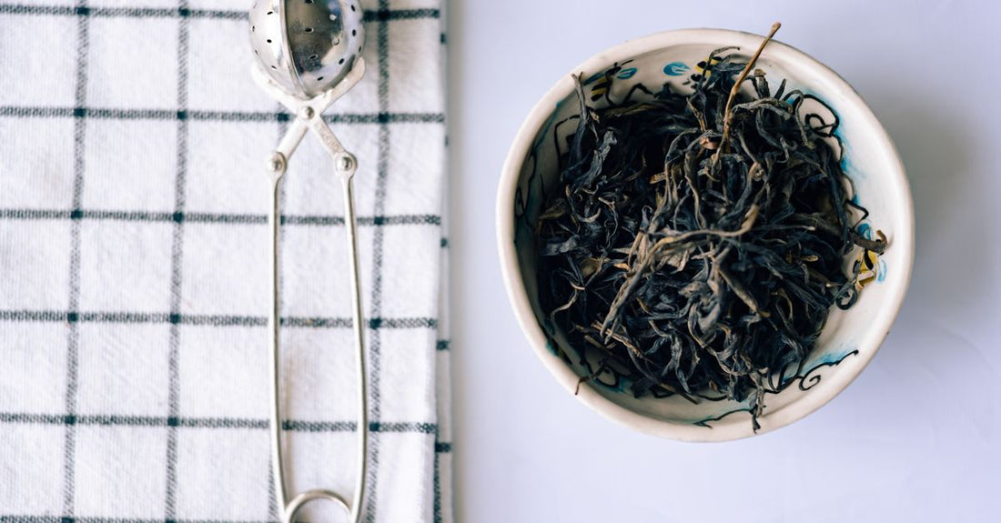 Green tea leaves in a ceramic bowl, visual for green tea buying guide UK