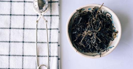Green tea leaves in a ceramic bowl, visual for green tea buying guide UK
