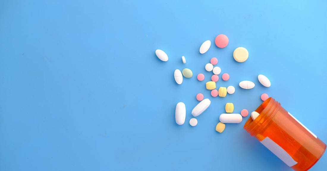 A flatlay of best vitamins UK 2026 supplement bottles and capsules on a light background.