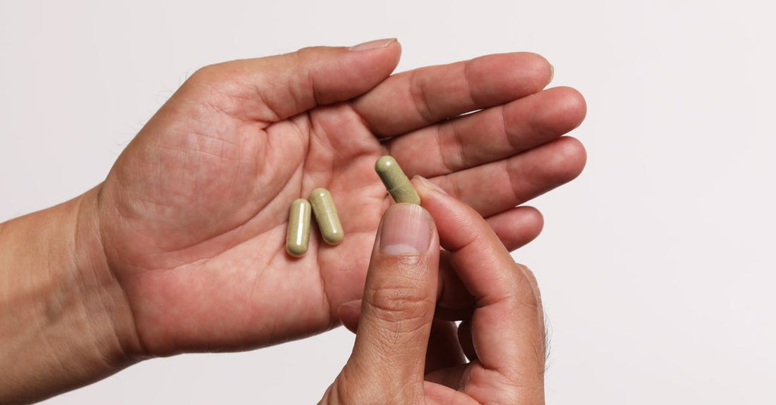 Cranberry supplement capsules and a glass of cranberry juice on a white background, illustrating cranberry juice vs supplements